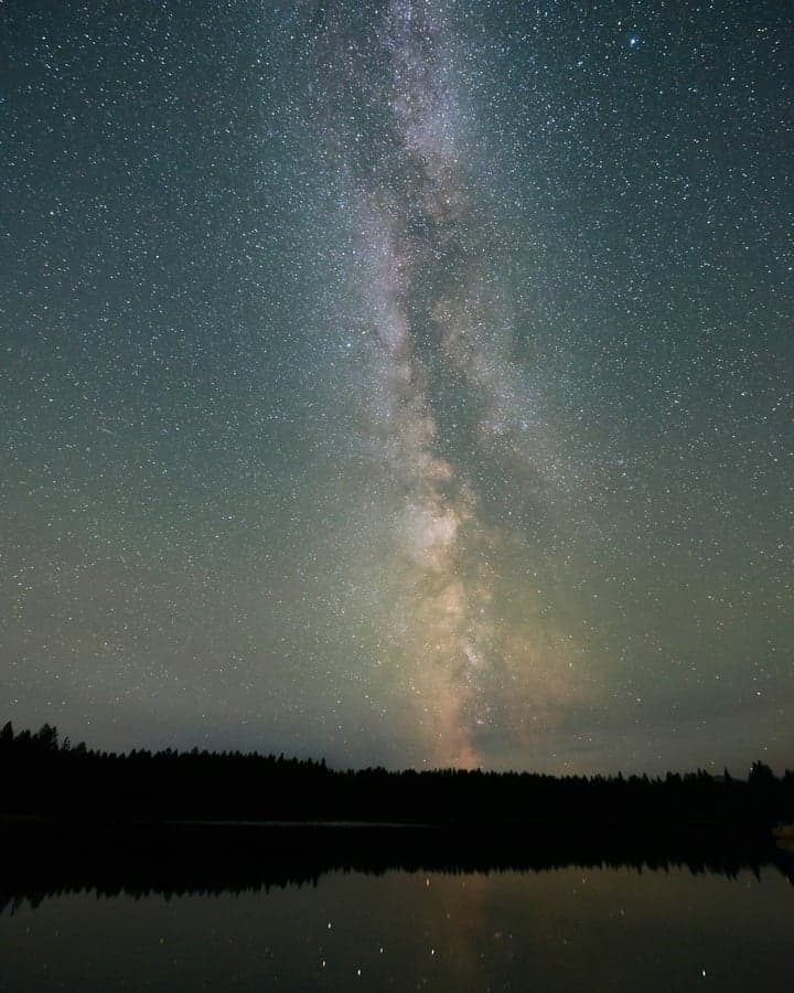 A starry sky reflected on a still lake — the Cosmic Board placing the three pillars on a circle